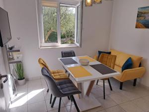 a living room with a dining room table and chairs at La Petite Maison in Splitska