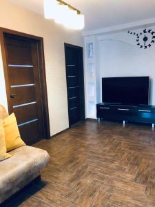 een woonkamer met een bank en een flatscreen-tv bij Apartamentai Kęstučio g. Šilutėje in Šilutė