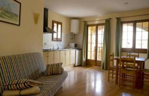 a living room with a couch and a table and a kitchen at Apartamentos Cal Ratero in Maçanet de Cabrenys