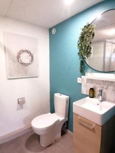 La salle de bains est pourvue de toilettes blanches et d'un lavabo. dans l'établissement le Ti'Cocoon, à Langueux