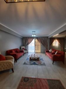 ein Wohnzimmer mit roten Sofas und einem Tisch in der Unterkunft غرفة بمنزل هادئ مناسب للعائلة in Kairo