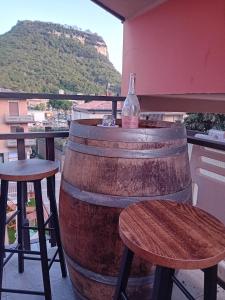 a bottle of wine sitting on top of a barrel at Garda City Home Family Apartments in Garda