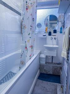 a bathroom with a shower curtain and a sink at Centrally Located Comfortable Room in London in London