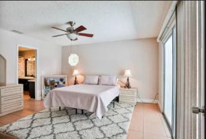 a bedroom with a bed and a ceiling fan at Casalana in Palm Coast +30 photos
