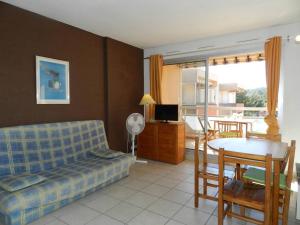 uma sala de estar com um sofá e uma mesa em Appartement Bormes-les-Mimosas, 2 pièces, 4 personnes - FR-1-251-812 em Bormes-les-Mimosas
