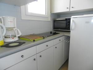 y cocina con encimera, microondas y nevera. en Appartement Le Lavandou, 1 pièce, 3 personnes - FR-1-251-804, en Le Lavandou