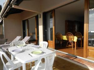 uma mesa de jantar branca e cadeiras num alpendre em Appartement Bormes-les-Mimosas, 2 pièces, 4 personnes - FR-1-251-807 em Bormes-les-Mimosas