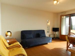uma sala de estar com um sofá azul e uma televisão em Appartement Bormes-les-Mimosas, 2 pièces, 4 personnes - FR-1-251-807 em Bormes-les-Mimosas