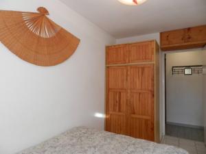 een slaapkamer met een bed en een houten kast bij Appartement Bormes-les-Mimosas, 2 pièces, 4 personnes - FR-1-251-810 in Bormes-les-Mimosas