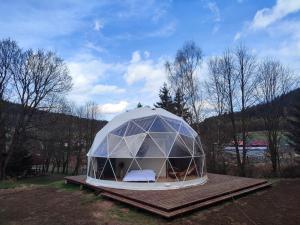 une grande tente en forme de dôme assise sur une plate-forme en bois dans l'établissement Forrest Glamp, à Mieroszów