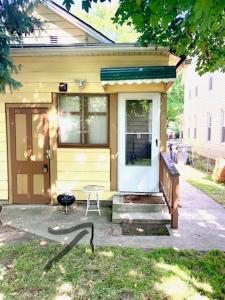 una pequeña casa amarilla con una puerta y una mesa en Cozy and Wonderful W47th, en Cleveland