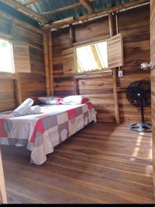Oso Hostel Cabaña Santa Marta في سانتا مارتا: غرفة نوم مع سرير في كابينة خشب