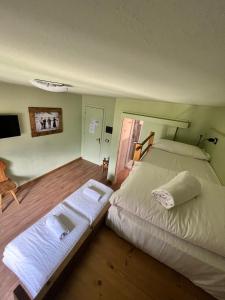 a bedroom with two beds and a tv on the wall at Hotel Riva Sport & Wellness in Vione