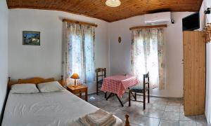 Schlafzimmer mit einem Bett, einem Tisch und einem Fenster in der Unterkunft Angelos Rooms in Mytilini