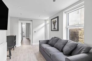 a living room with a gray couch and a window at Brand New 5 Bedroom House in Plymouth