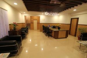 um escritório com uma secretária e cadeiras num quarto em Trinity Suites em Bangalore