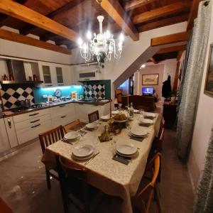 Casa Al Borghetto في Oriago: طاولة طعام كبيرة مع كراسي وثريا