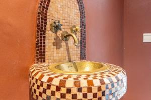 baño con lavabo de mosaico con grifo en Penthouse avec Jacuzzi privé à Marrakech, en Marrakech