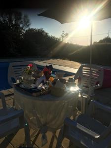 una mesa con comida en ella con el sol brillando en Domaine de la Rose, en Vaudelnay