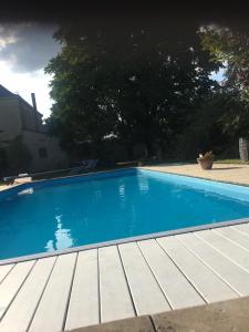una piscina azul con terraza de madera en Domaine de la Rose, en Vaudelnay
