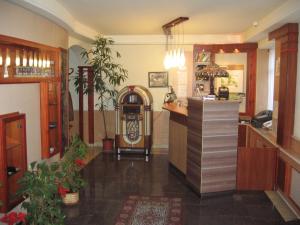 a lobby with a bar and a counter with plants at Hotel Arnold in Tata