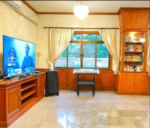a living room with a keyboard and a large window at 高尔夫花园泳池高端6卧别墅 in Ban Huai Yai