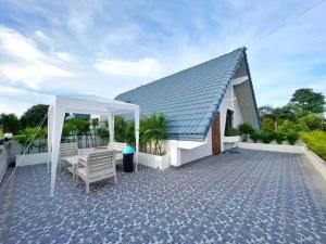 a house with a white roof and a patio at 高尔夫花园泳池高端6卧别墅 in Ban Huai Yai