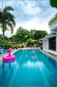 a swimming pool with a pink float in the middle at 高尔夫花园泳池高端6卧别墅 in Ban Huai Yai