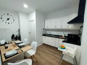 a kitchen with a table and chairs and a clock on the wall at Apartamento El Adoquín in Icod de los Vinos