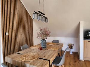 a dining room with a wooden table and chairs at Krásný apartmán REFRINO v přírodě in Železná Ruda