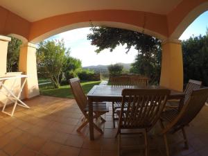 a table and chairs on a patio with a view at Residence Spiaggia Bianca in Golfo Aranci