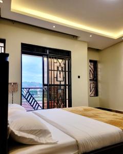 um quarto com uma cama grande e uma varanda em Chayil Loft Bahai em Kampala