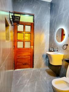 uma casa de banho com um WC, um lavatório e uma porta em Chayil Loft Bahai em Kampala