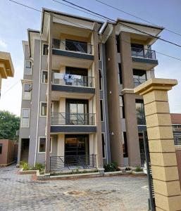 um grande edifício de apartamentos com varandas numa rua em Chayil Loft Bahai em Kampala