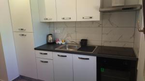a kitchen with white cabinets and a sink at Apartment D&M in Premantura