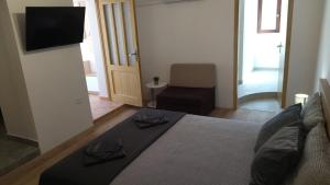 a bedroom with a bed and a television and a chair at Apartment D&M in Premantura