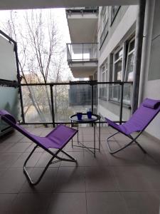 un balcone con sedie viola e un tavolo su un edificio di Villa Natali Warszawa a Varsavia