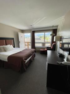 a hotel room with a bed and a balcony at Rondo Motel in Golden