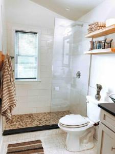 a white bathroom with a shower and a toilet at Modern Treehouse, close to downtown and beach in Wilmington
