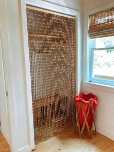 a shower in a room with a red chair at Modern Treehouse, close to downtown and beach in Wilmington