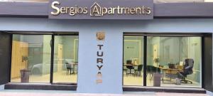 einen Vorratsraum mit Glastüren, Tischen und Stühlen in der Unterkunft Sergios Apartments 6 in Alexandroupoli