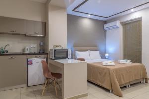 Zimmer mit einer Küche und einem Bett mit einer Mikrowelle. in der Unterkunft Sergios Apartments 6 in Alexandroupoli