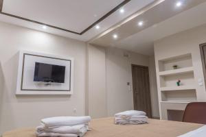 Zimmer mit einem Tisch und einem TV an der Wand in der Unterkunft Sergios Apartments 6 in Alexandroupoli