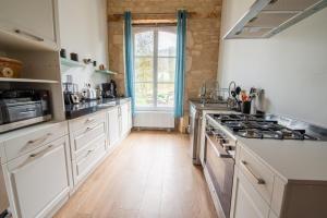 a kitchen with white cabinets and a stove at Abbaye de l'Etanche - Un cadre naturel exceptionnel - Patrimoine - in Rollainville