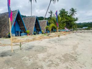 szereg domów na plaży z flagami w obiekcie Northern Prince Beach Resort w mieście General Santos
