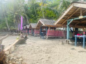 rząd drewnianych schronów na plaży w obiekcie Northern Prince Beach Resort w mieście General Santos
