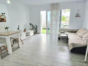 sala de estar con sofá y mesa en Apartamento con piscina a 500m de la playa, en Costa Teguise