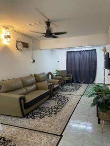 a living room with couches and a ceiling fan at #KangaQHomestay99 in Kangar