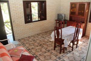 a room with a table and chairs and a tv at Residencial Aracuã in Bombinhas