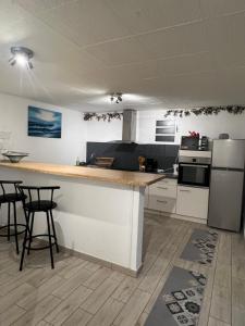 eine Küche mit einer Theke und ein paar Stühlen darin in der Unterkunft Appartement agréable et calme in Sainte-Suzanne